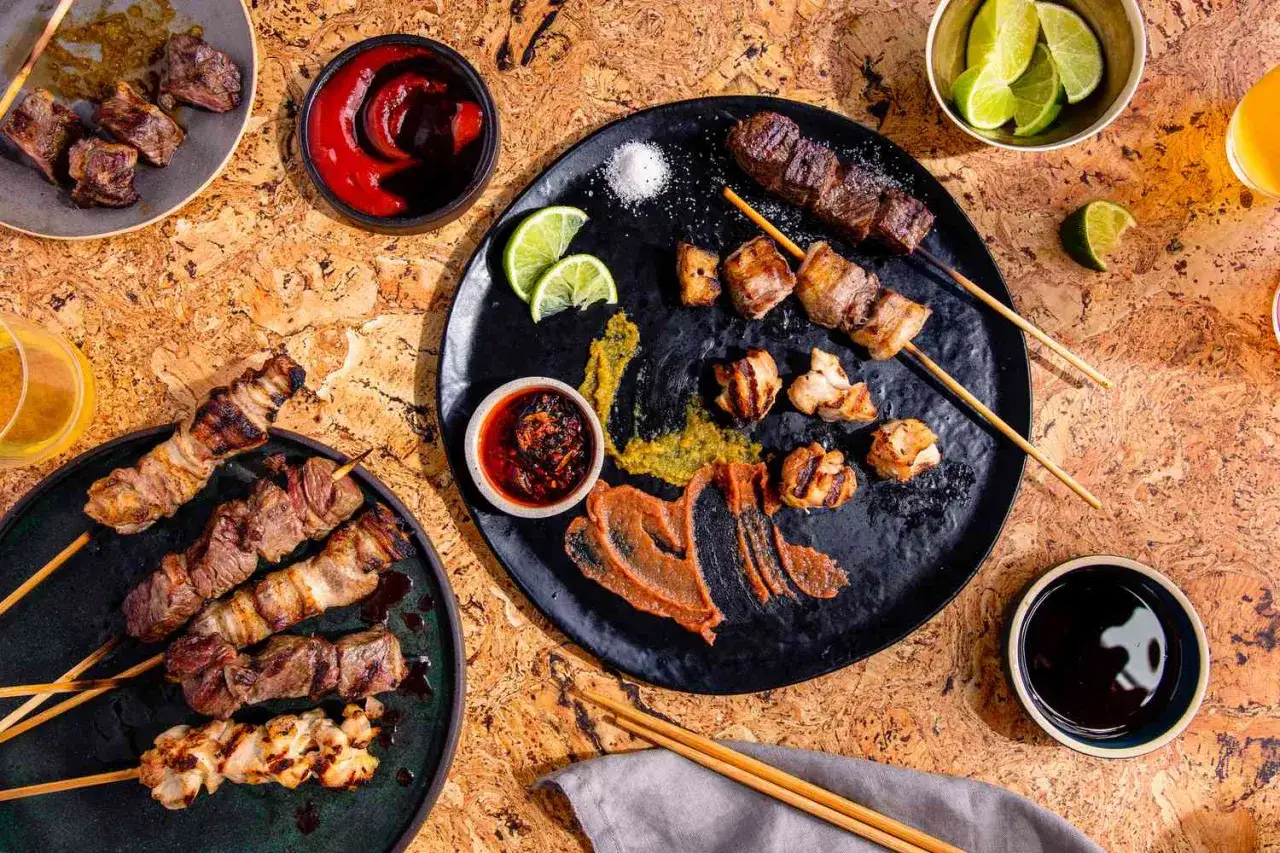 Grillspett med k&ouml;tt och kyckling, serverade med dipps&aring;ser och lime. Ett perfekt yakiniku recept f&ouml;r en festm&aring;ltid.