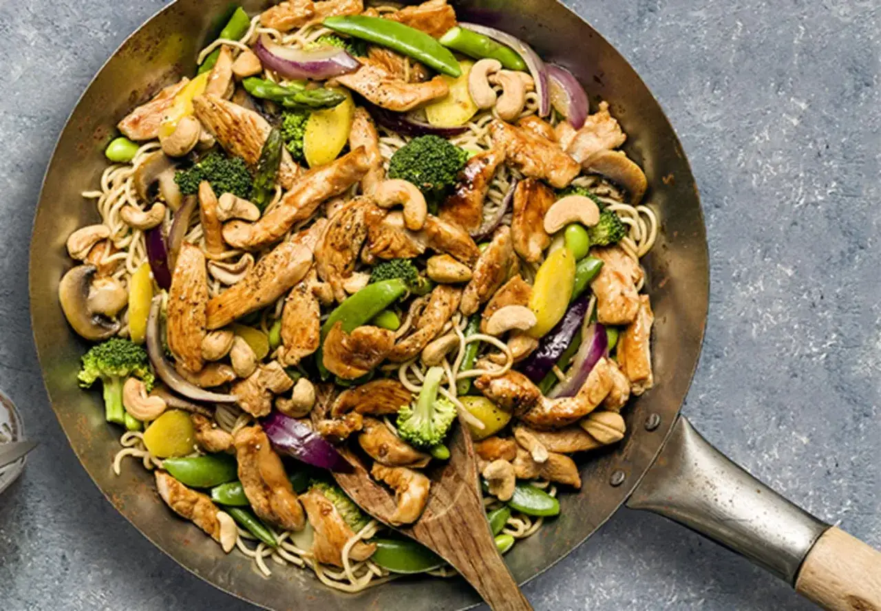 En wok med strimlad kyckling, nudlar, broccoli, socker&auml;rtor, cashewn&ouml;tter och r&ouml;dl&ouml;k. Ett perfekt strimlad kyckling recept f&ouml;r en snabb middag.