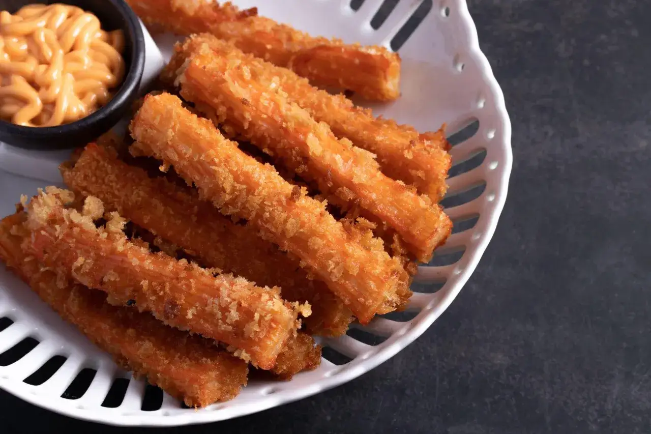 Chrupiące paluszki surimi w panierce, idealne na ciepło. Podane z pysznym, kremowym sosem.