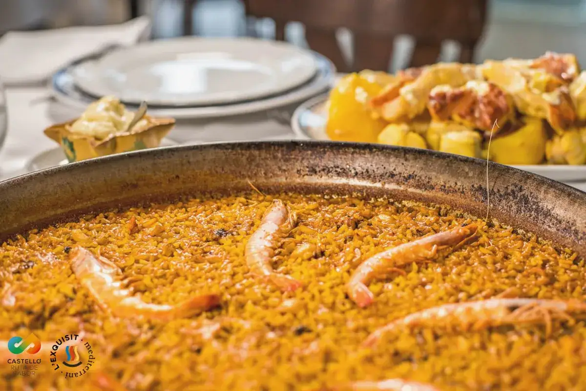Paella marinera, un plato emblemático de la comida típica de Castellón, con gambas y arroz dorado.