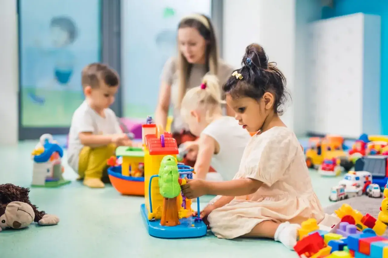 Dzieci bawią się klockami w żłobku. Zastanawiasz się, ile kosztuje żłobek miesięcznie?