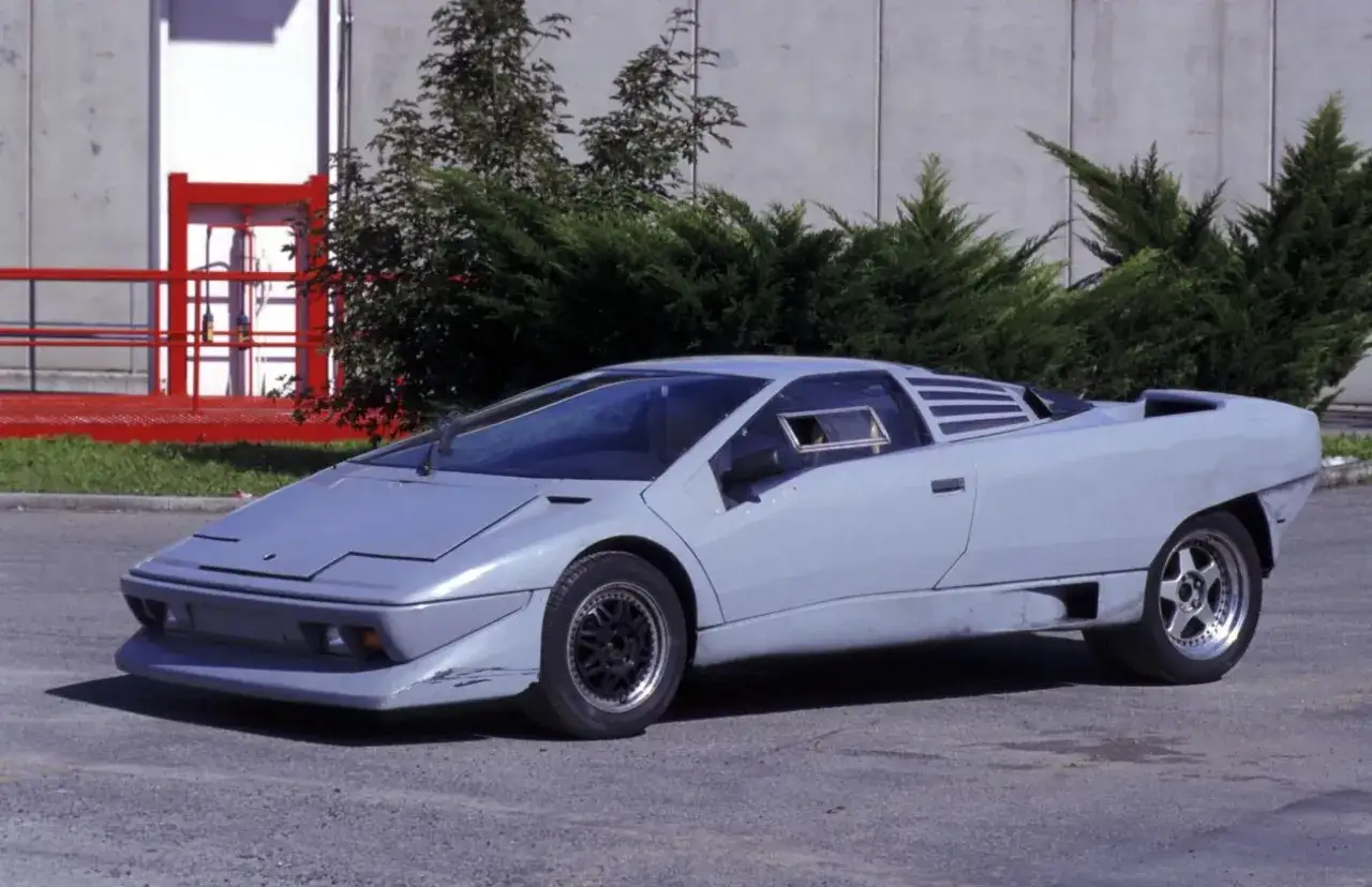 Prototyp Lamborghini Diablo w surowej, szarej karoserii, z charakterystycznymi wlotami powietrza i ostrymi liniami.