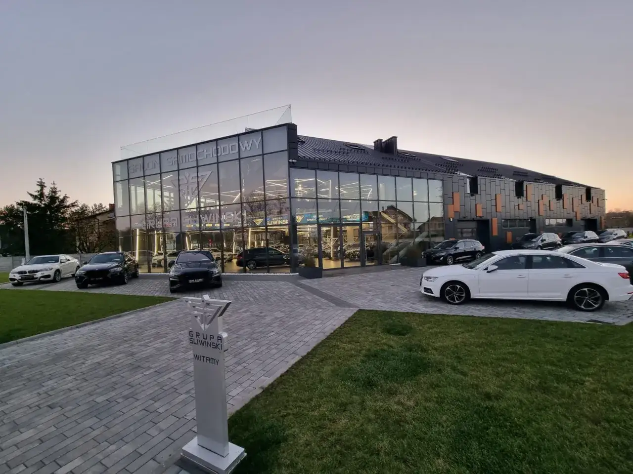 Nowoczesny salon samochodowy z przeszkloną fasadą, gdzie można znaleźć wiele luksusowych aut. Sprawdźcie sami, jakie są showroom opinie!