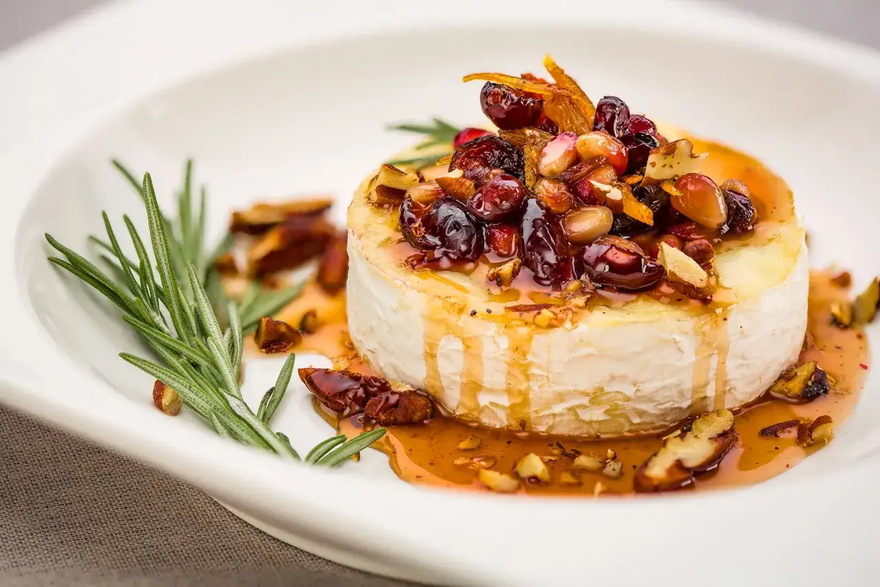 Queso camembert horneado con frutos secos y miel, un cl&aacute;sico de los entrantes t&iacute;picos de Francia.