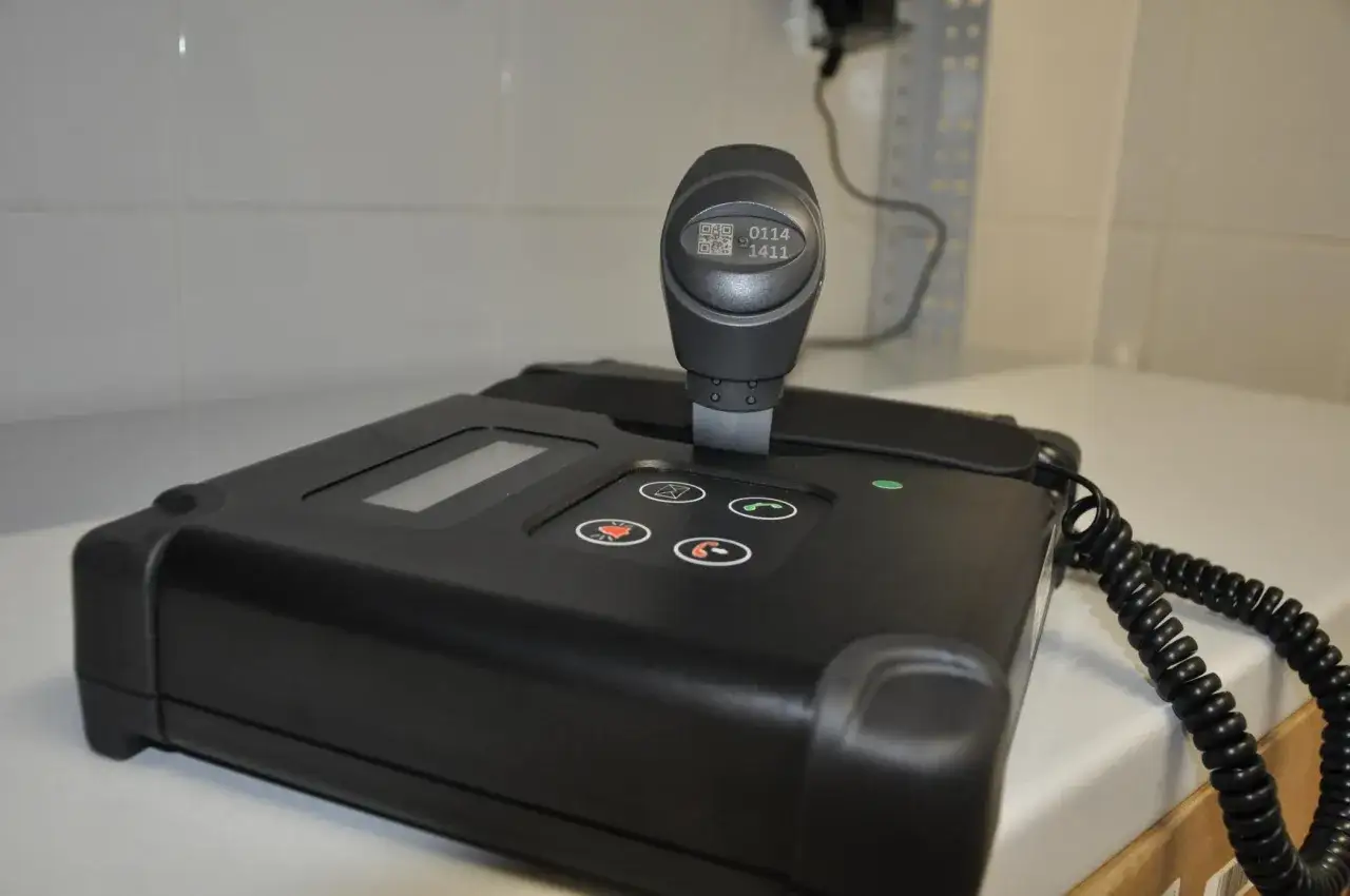 Urządzenie do dozoru elektronicznego z uchwytem i wyświetlaczem.