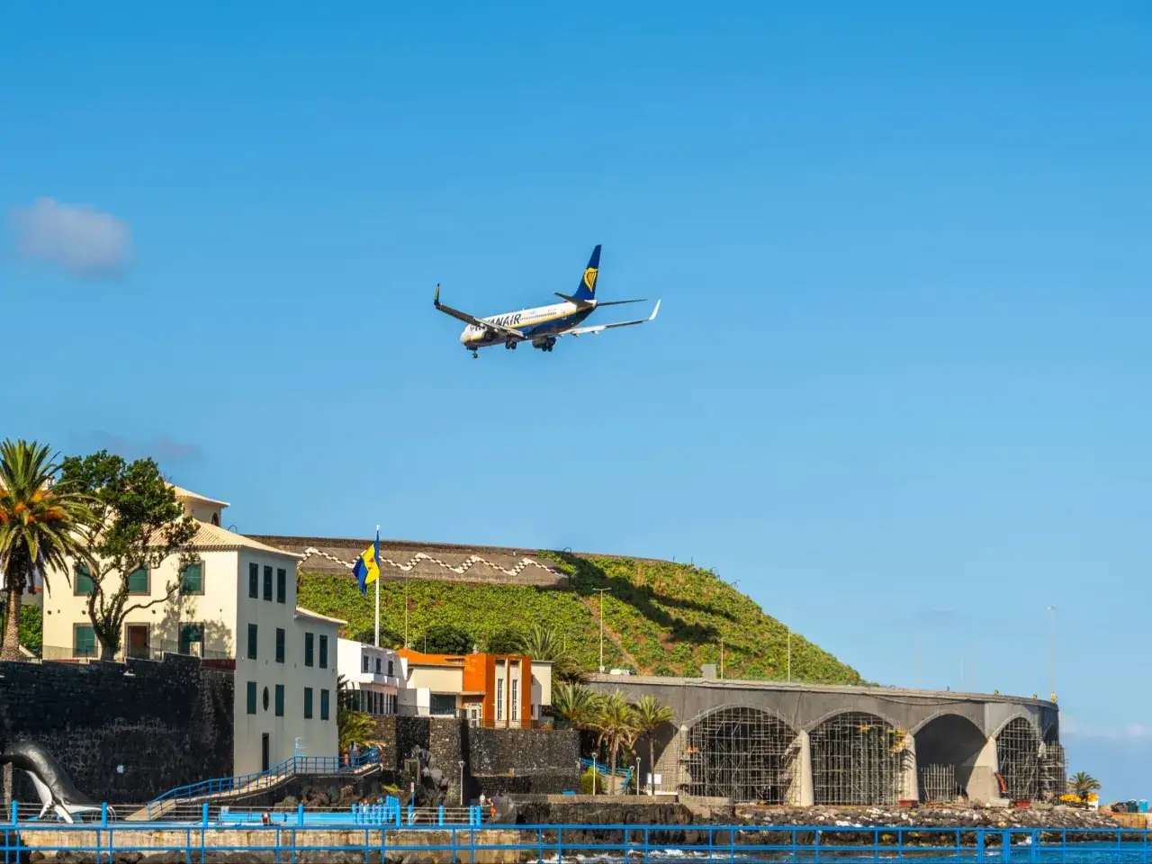 Samolot Ryanair zbliża się do lądowania na Maderze. Lot trwa krótko, a widok na ocean i budynki jest piękny.