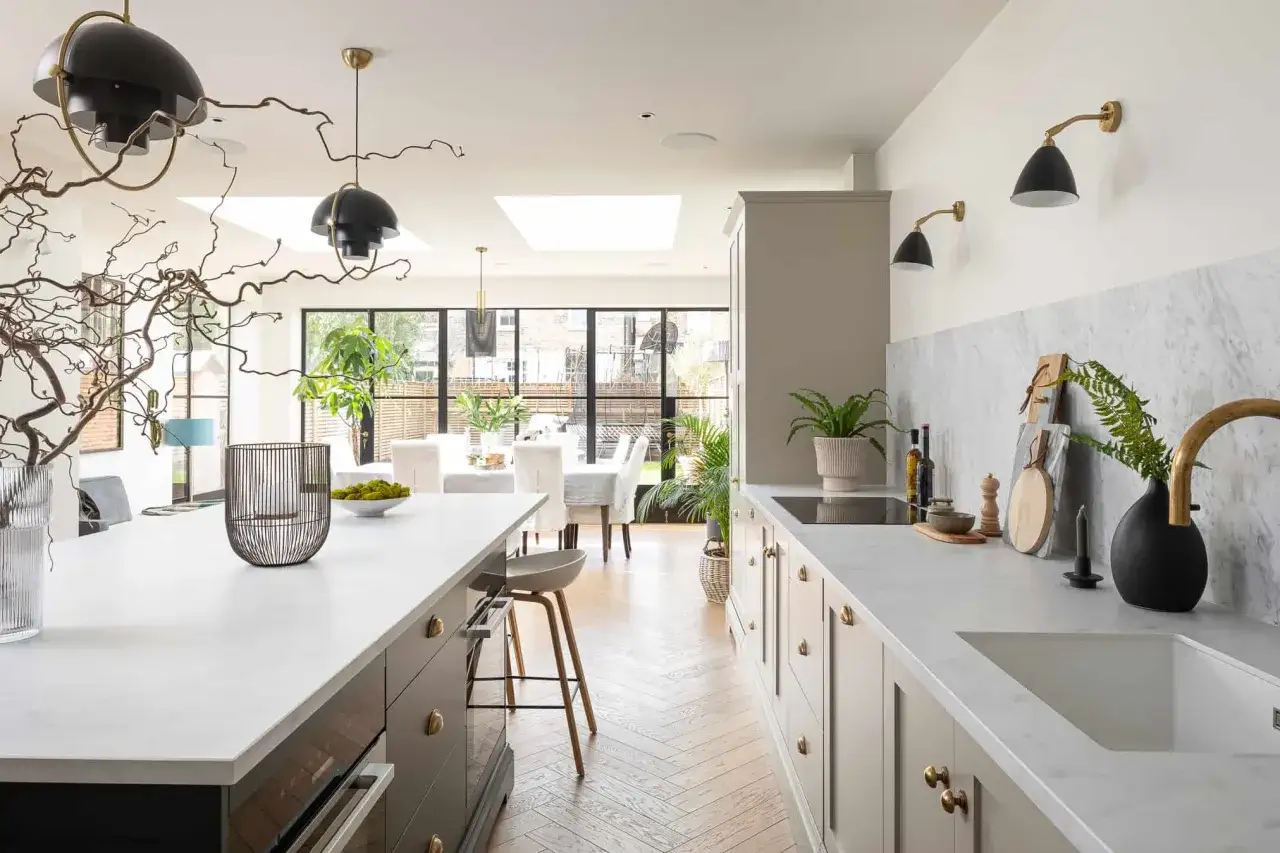 Modern kitchen and dining room design with a large island, sleek cabinetry, and a bright dining area with large windows.