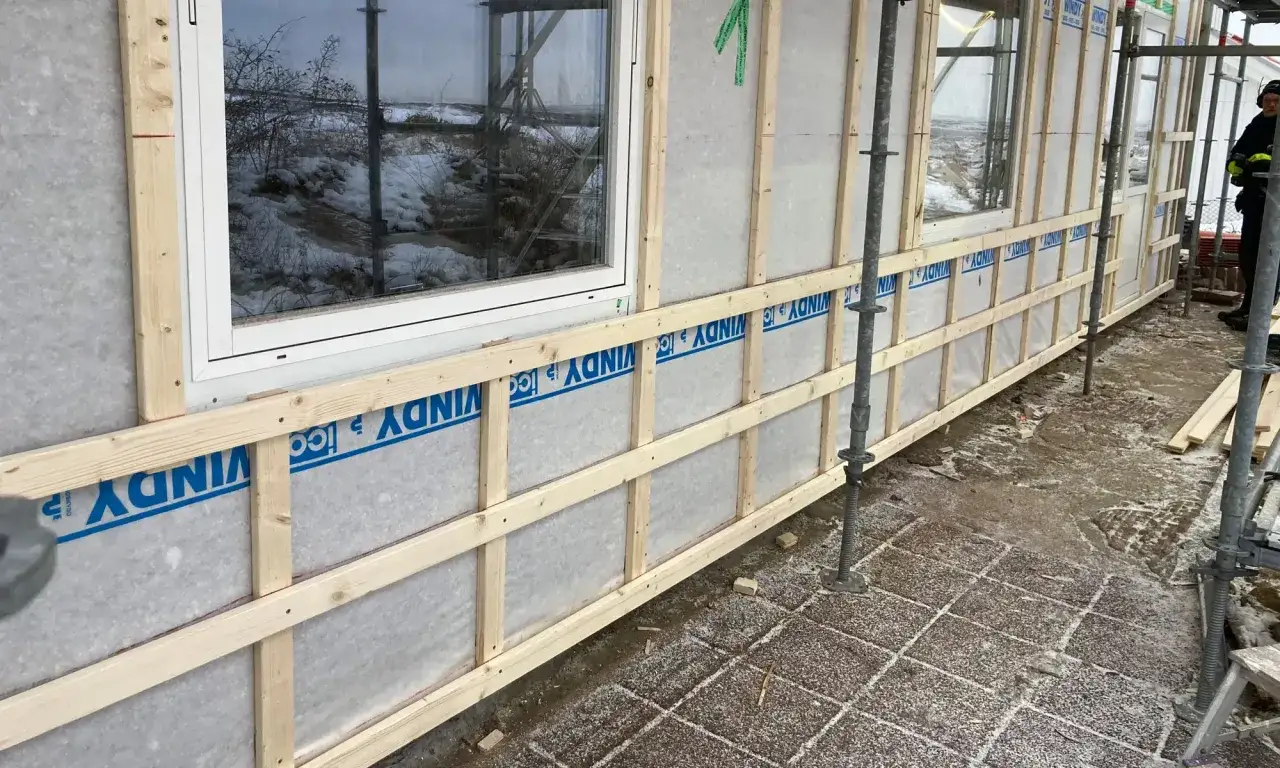 Byggnation av fasad med vindskydd och en ram f&ouml;r gammaldags lockpanel.