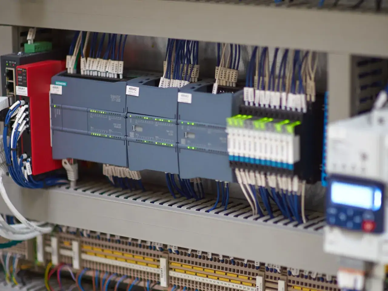 Panel sterowania z modułami Siemens SIMATIC S7-1200, okablowanie i zasilacz. To serce systemu automatyki, gdzie programowanie PLC ożywia maszyny.