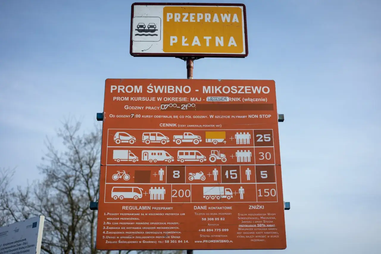 Tablica informacyjna promu Świbno-Mikoszewo. Prom kursuje od maja do września, godziny pracy 7:00-21:00. Cennik i regulamin przeprawy.