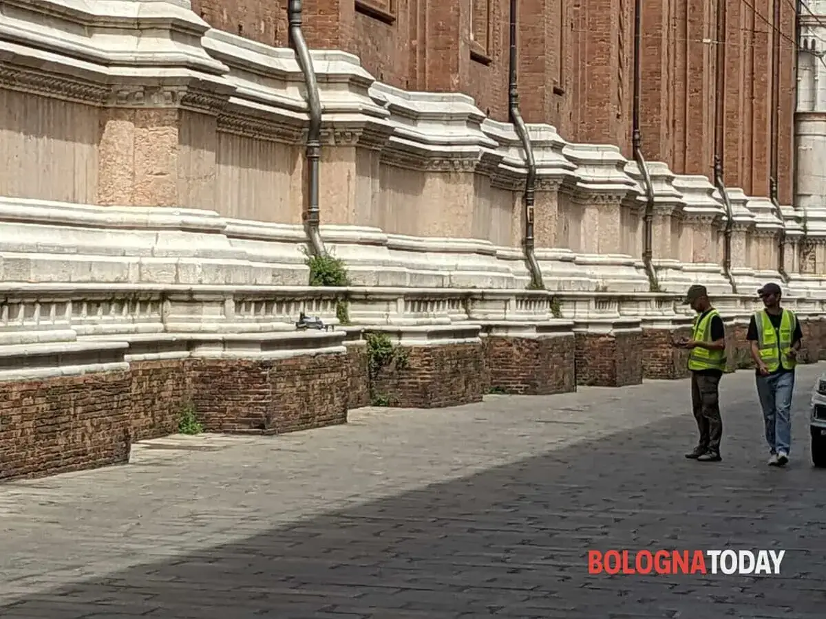 Due uomini con giubbotti ad alta visibilit&agrave; controllano un drone, forse in attesa dell'autorizzazione volo drone comune per riprese aeree.