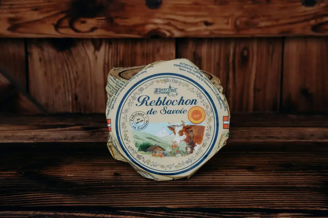 Reblochon de Savoie, un fromage au lait cru, &eacute;voque son origine montagnarde avec une vache et des chalets sur son emballage.