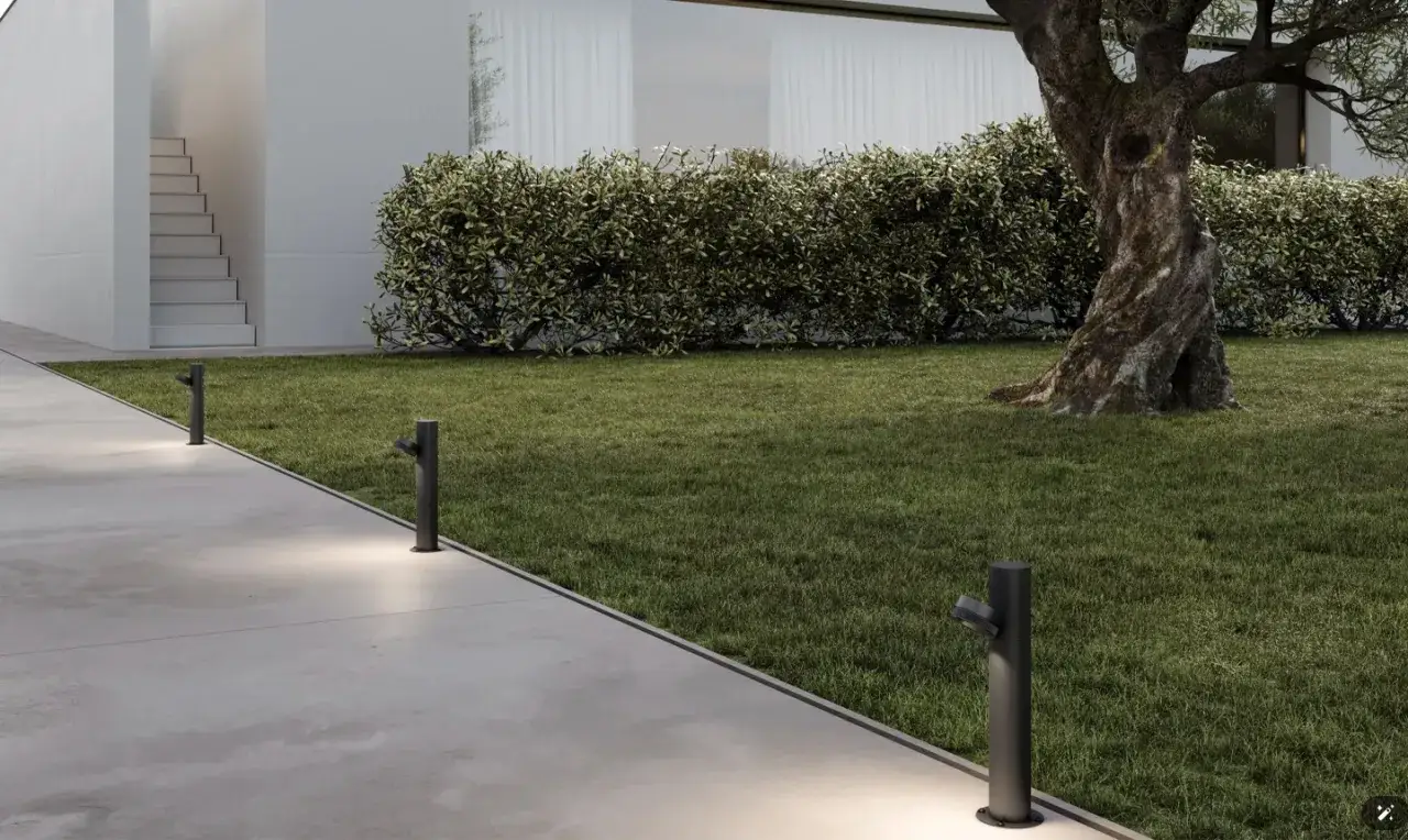 Illumina il tuo cortile in cemento con luci da giardino moderne. Un vialetto in cemento, prato verde, siepe e un ulivo creano un'atmosfera accogliente.