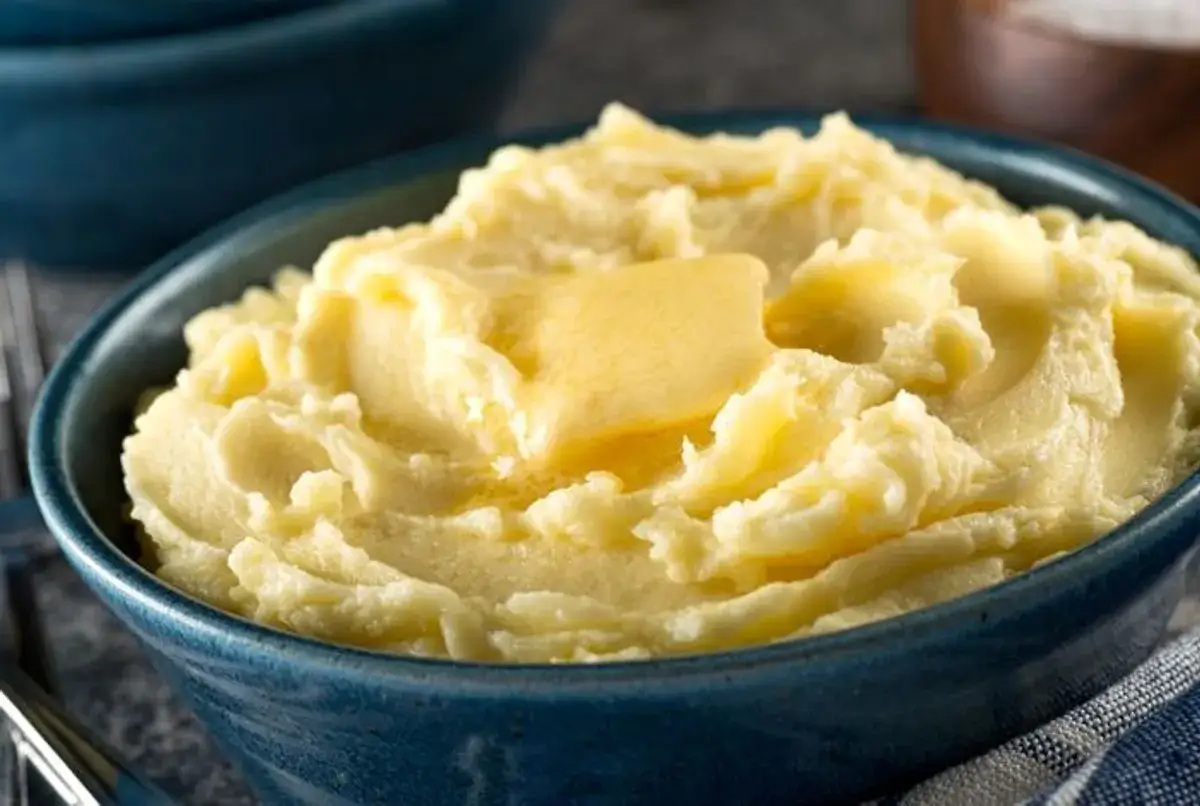 Un bol de purée maison crémeuse, surmonté d'une belle noisette de beurre fondante. Un délice réconfortant.