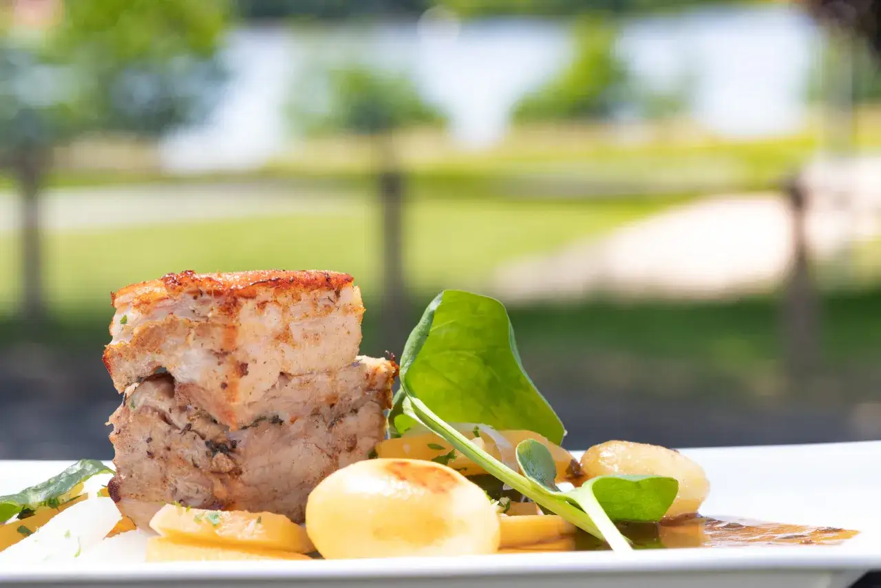 Un plat de poitrine de veau croustillante, accompagnée de pommes de terre et d'une touche verte. Une belle recette pour un repas d'été.