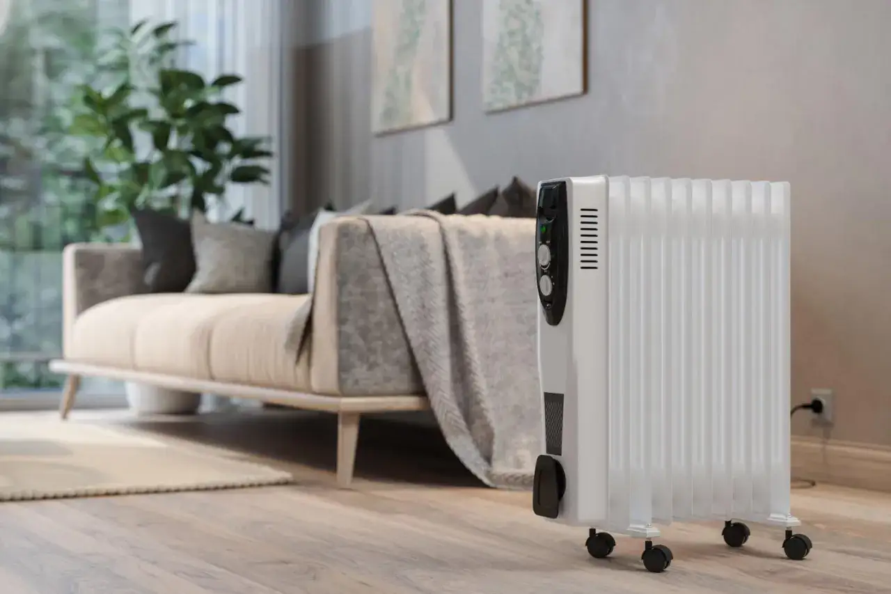 Un radiateur électrique blanc sur roulettes dans un salon moderne. Un avis sur ce type de chauffage électrique est le bienvenu.