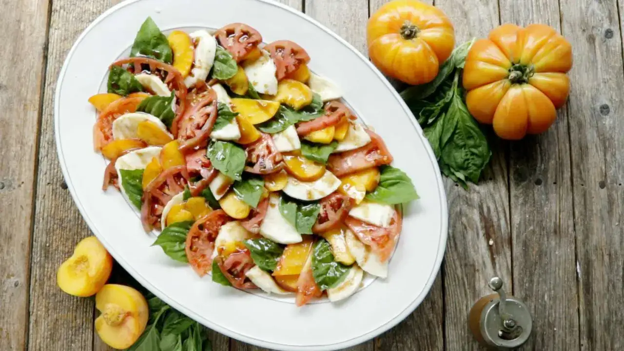 En fräsch italiensk sallad med tomater, mozzarella och basilika, perfekt som tillbehör till lasagne.