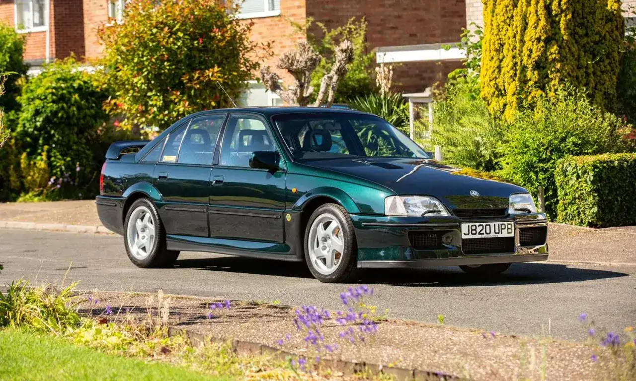 Zielony Lotus Omega z lat 90. na tle domu i zieleni.