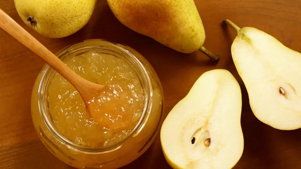 Un vasetto di marmellata di pere fatto in casa, con pere intere e tagliate intorno.