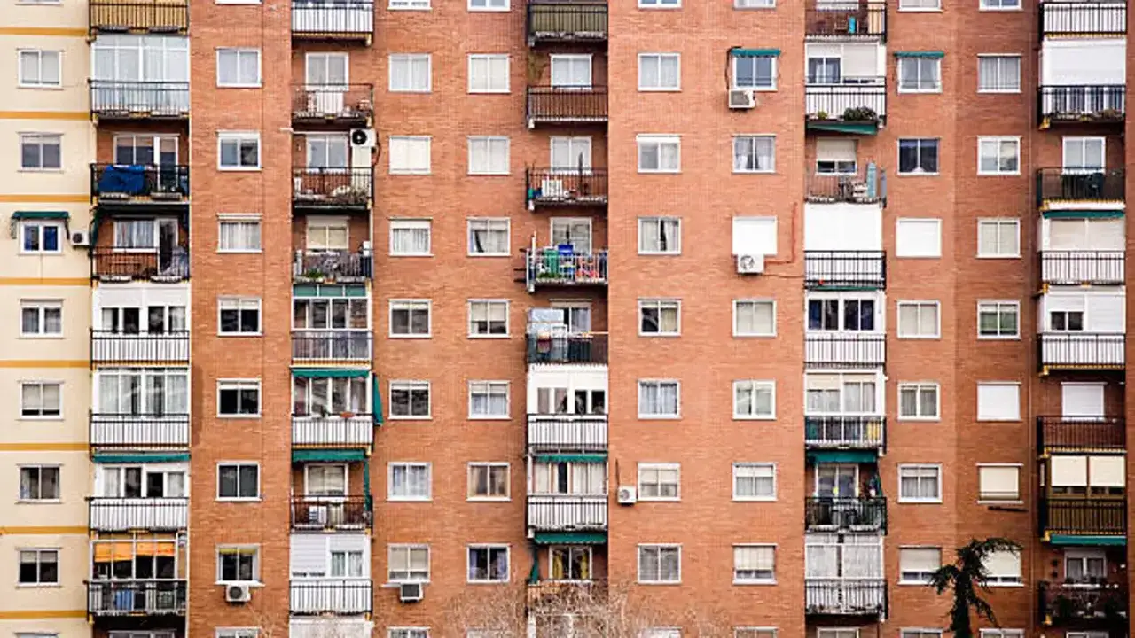 Fachada de edificio de ladrillo visto con m&uacute;ltiples balcones y ventanas. Se aprecia el pleno dominio de la arquitectura urbana.
