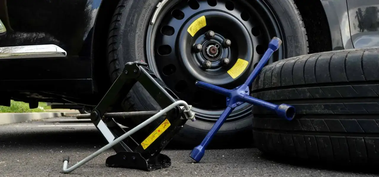 Cric, chiave a stella e ruota di scorta pronti per controllare la pressione.
