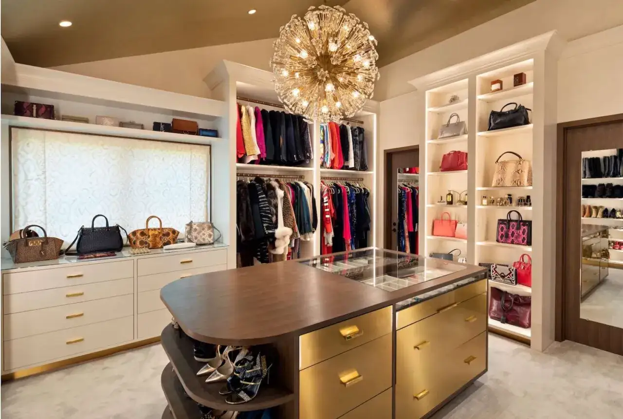 Un vestidor de lujo con ropa, bolsos y zapatos organizados. Las medidas del vestidor permiten un espacio amplio para cada prenda.
