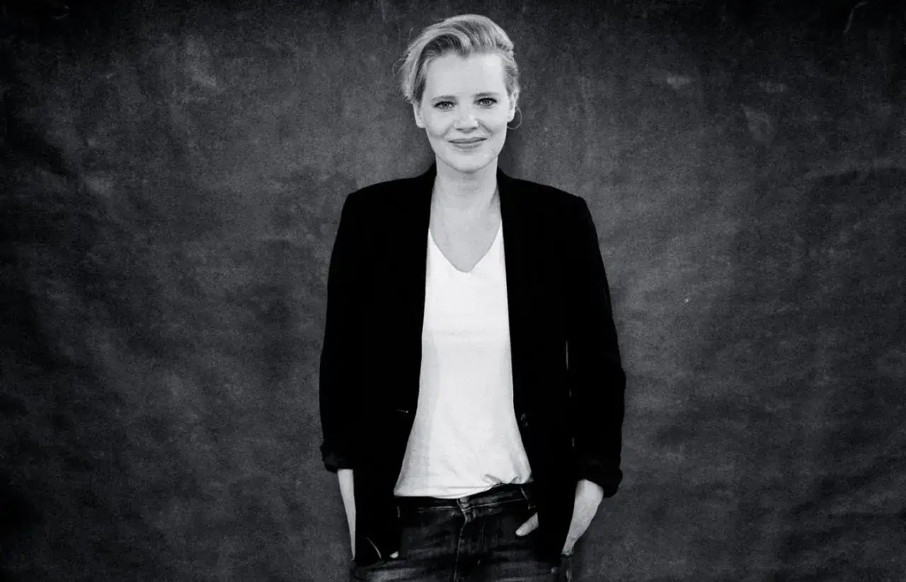 Joanna Kulig, znana z wielu wspaniałych **filmów**, pozuje w czarnej marynarce i białej koszulce.