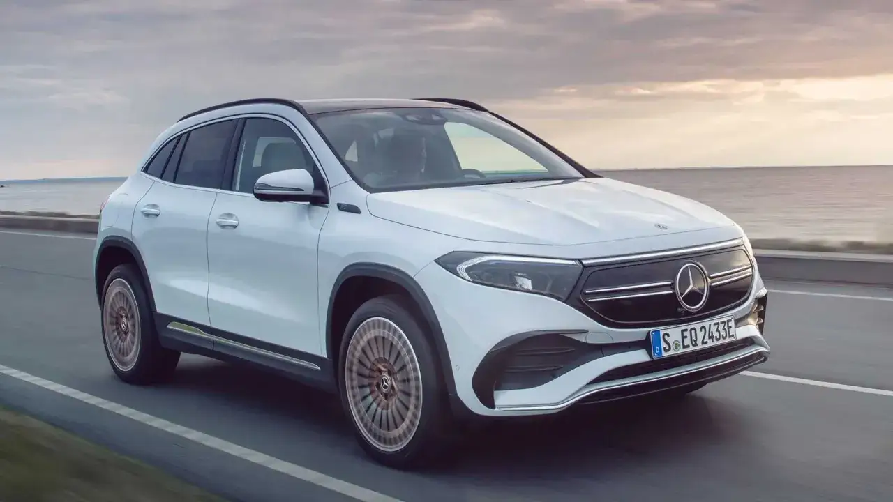Biały Mercedes EQA jedzie wzdłuż wybrzeża. Elektryczny SUV z nowoczesnym designem.