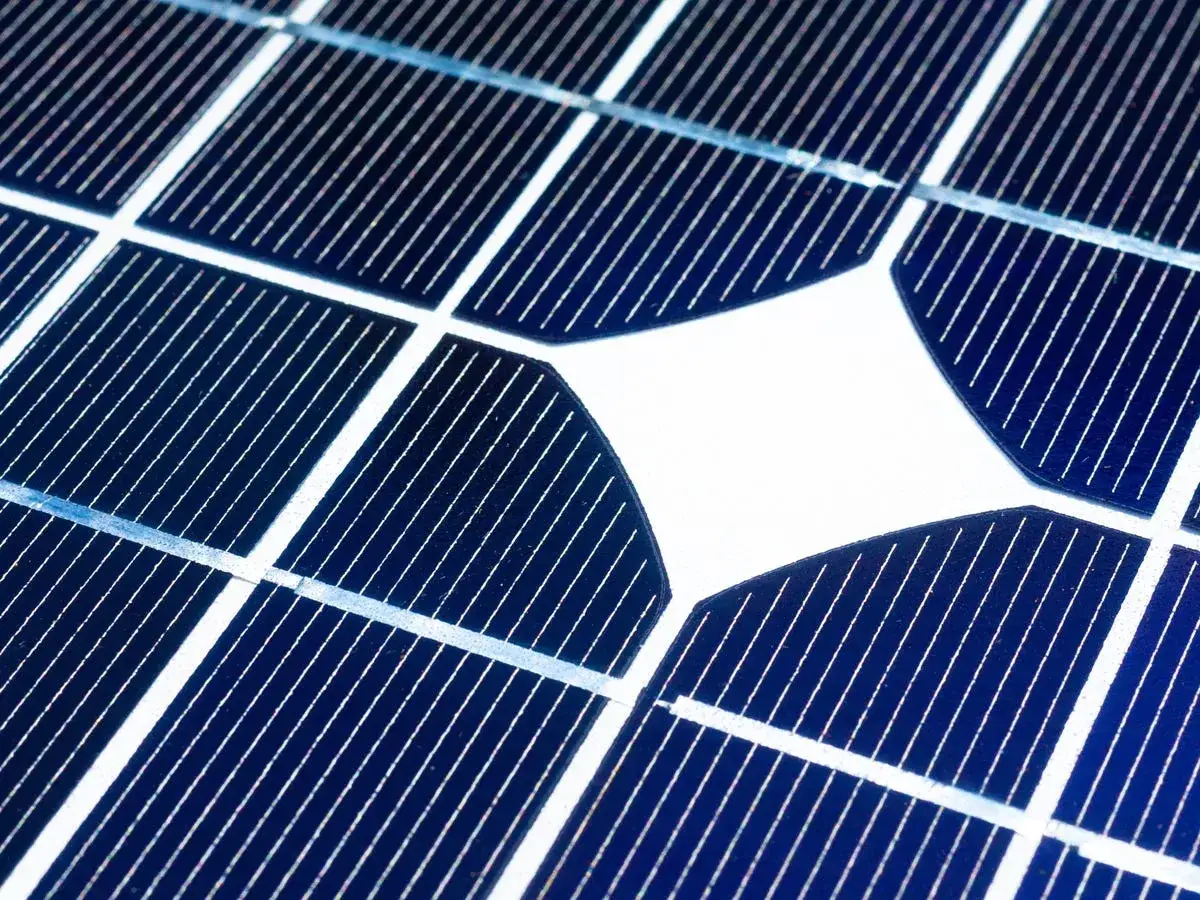 Zbliżenie na niebieskie ogniwa fotowoltaiczne z białymi liniami. To przyszłość energetyki, najmocniejsze panele fotowoltaiczne.