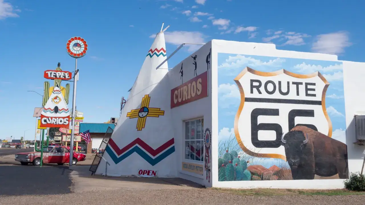 Kolorowy sklep z pamiątkami w kształcie tipi przy Route 66. Mural z bizonem i znakiem drogowym Route 66.