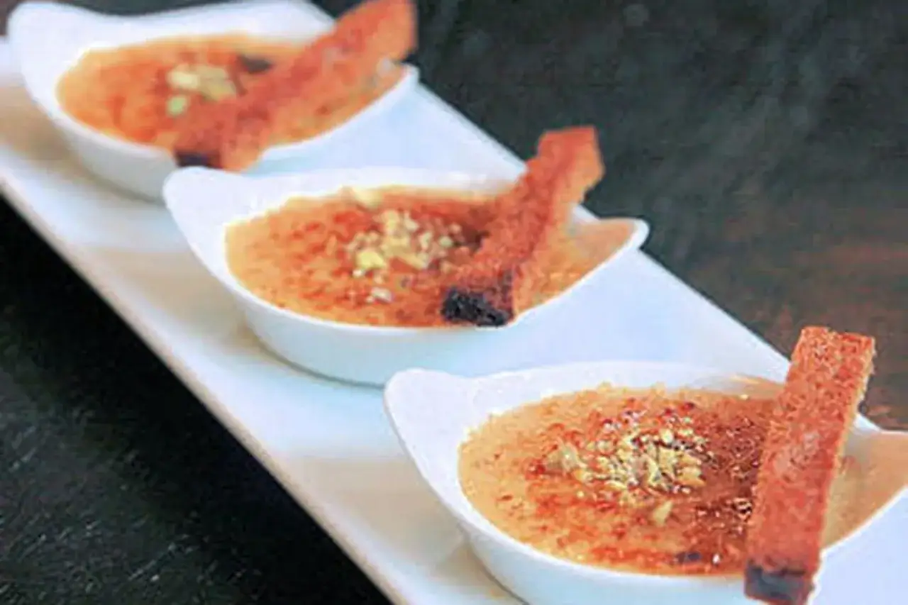 Trois ramequins de cr&egrave;me br&ucirc;l&eacute;e au foie gras, garnie de pistaches concass&eacute;es et d'une tuile croustillante.