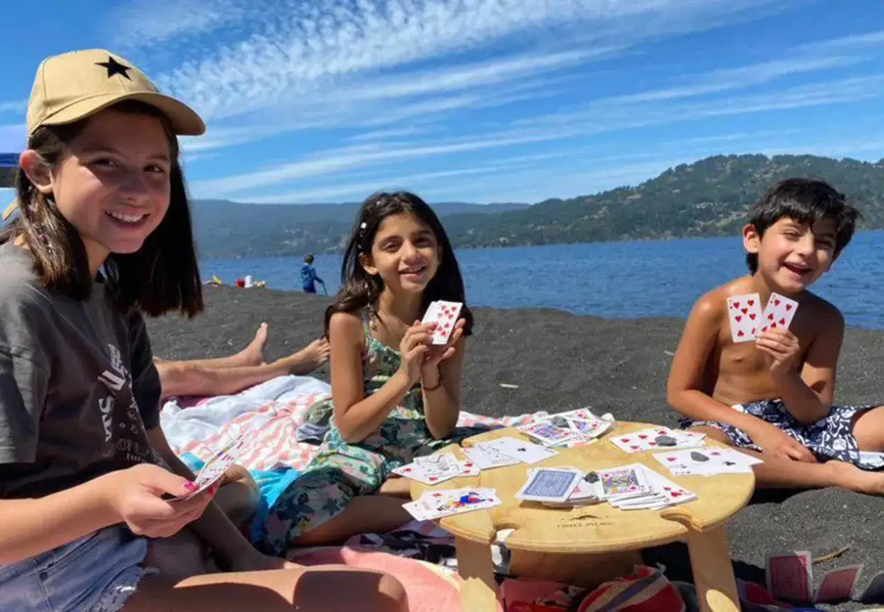 Ni&ntilde;os jugando a las cartas en un picnic en la playa. &iexcl;Excelentes ideas para picnic con ni&ntilde;os!