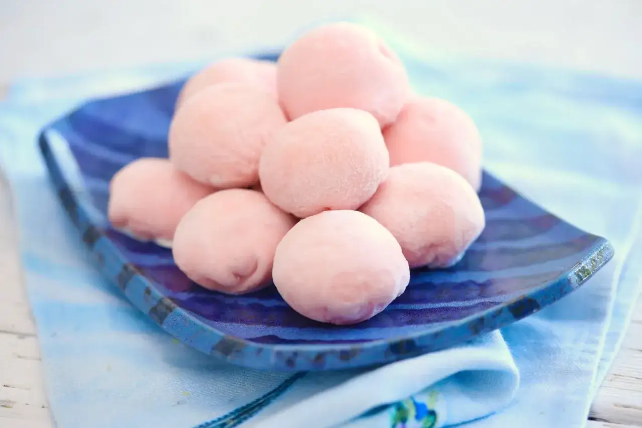 Zuckersüße, rosafarbene Mochi-Bällchen auf einer blauen Platte. Perfekt zum **Mochis selber machen** und Genießen.