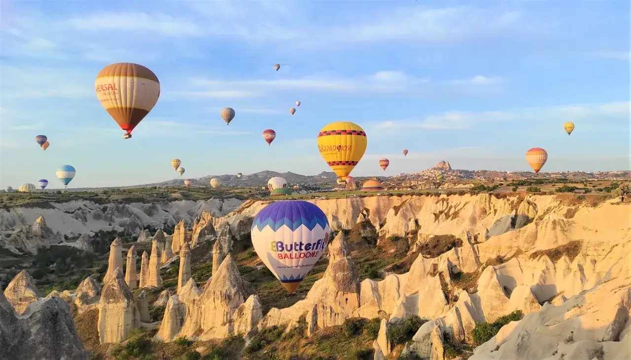 Kapadocja balony unoszą się nad bajkowymi formacjami skalnymi o wschodzie słońca.