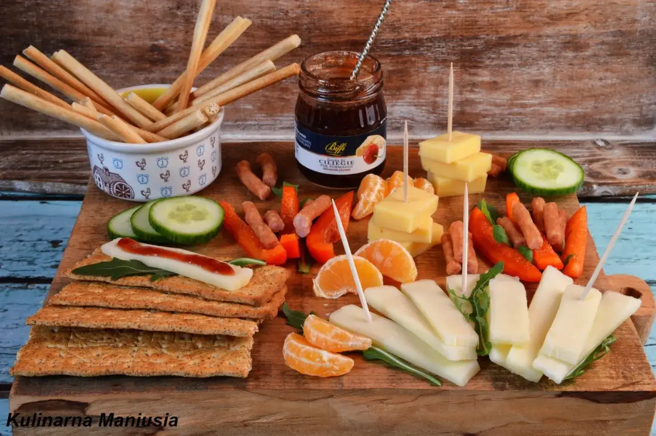 Pyszne menu na sylwestra w domu: paluszki, ser, kiełbaski, papryka, ogórek, mandarynki i dżem.