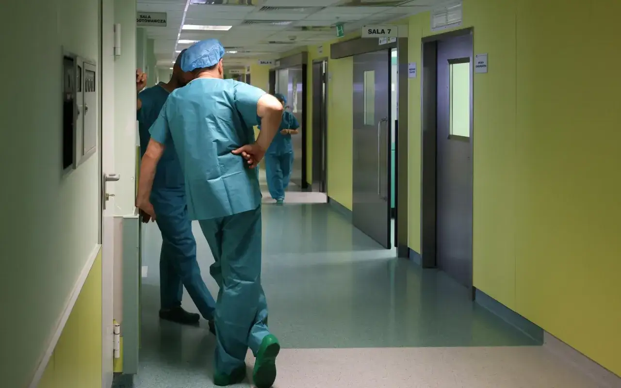 Lekarze w zielonych fartuchach idą korytarzem szpitalnym. Zastanawiasz się, ile zarabia lekarz?