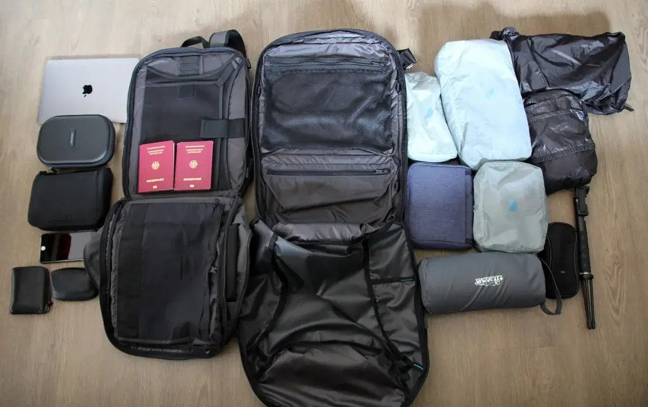 Przygotowany do podróży z Eurowings: plecak, paszporty, laptop, telefon, portfel i organizer na bagaż.