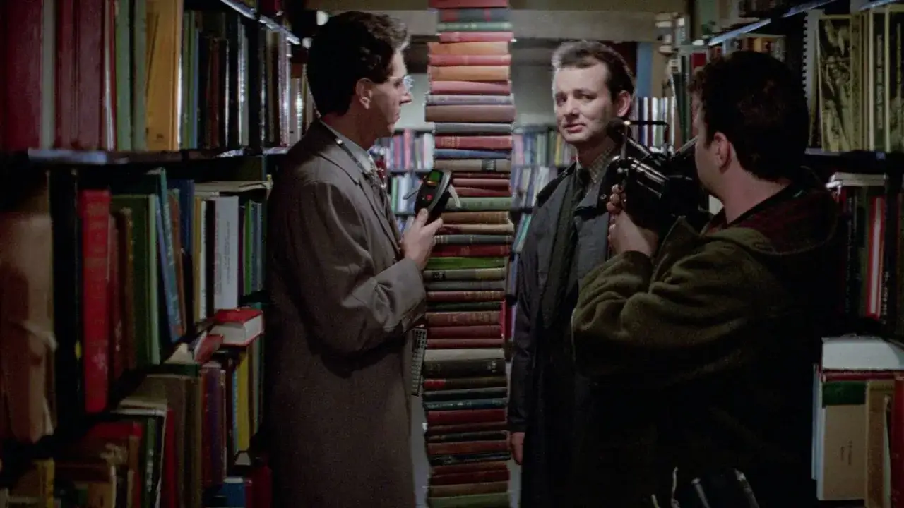 W bibliotece, wśr&oacute;d regał&oacute;w pełnych książek, Bill Murray z kamerą obserwuje kolegę trzymającego dziwne urządzenie. Czy to początek jakiegoś horroru?