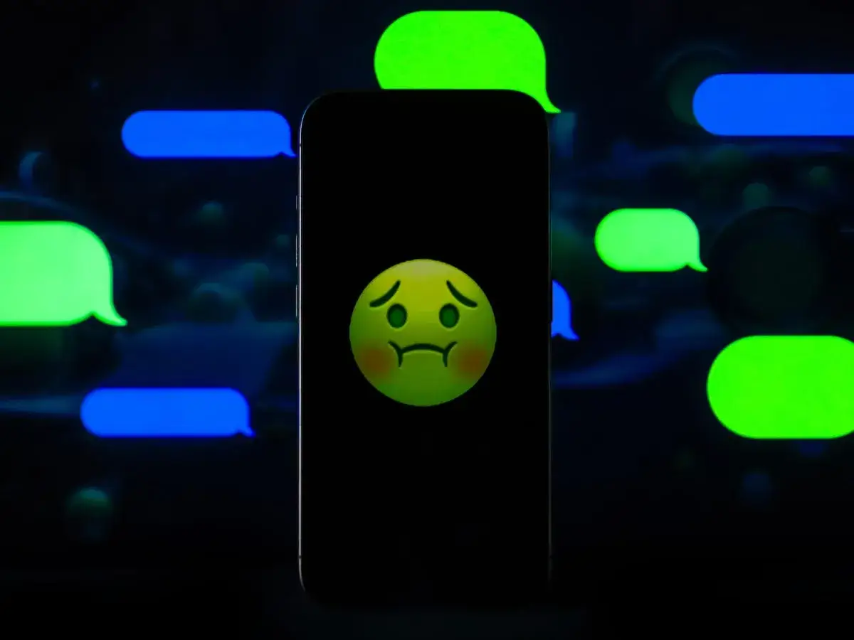 Smutna buźka na ekranie telefonu, otoczona dymkami czatu. Czy to problem z iMessage?