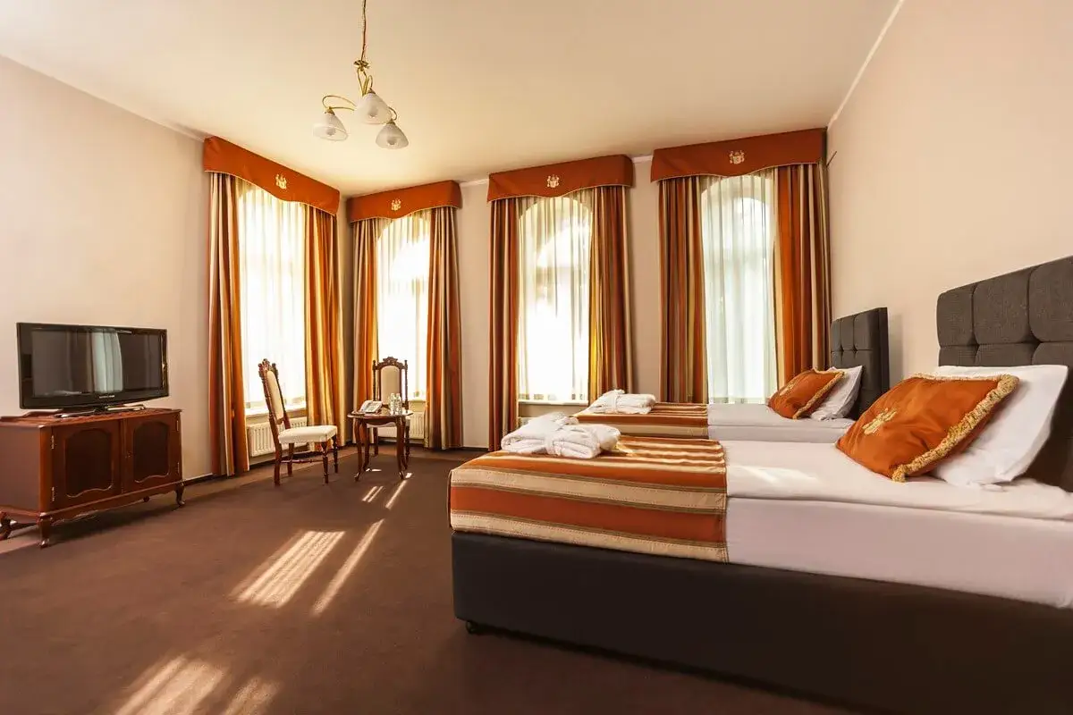 Pok&oacute;j w sanatorium z dwoma ł&oacute;żkami, szlafrokami i widokiem na okna. Zastanawiasz się, jaki wybrać pok&oacute;j w sanatorium?