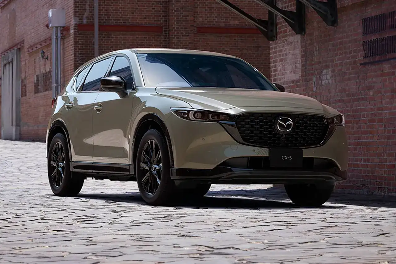 Beżowa Mazda CX-5 na brukowanej ulicy. Zastanawiasz się, jaki silnik wybrać? Forum pomoże Ci podjąć decyzję.