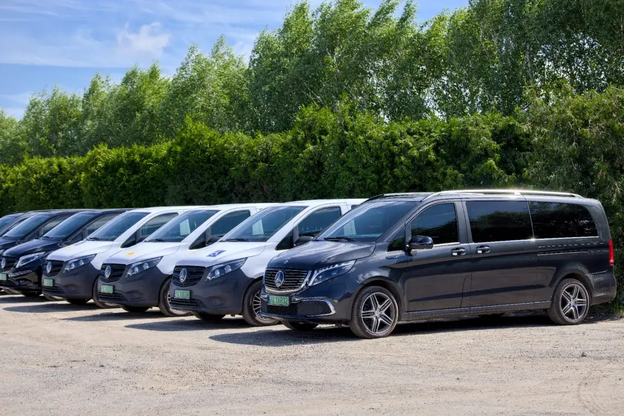 Rząd ciemnych i białych busów gotowych do przewozów busem po Polsce.