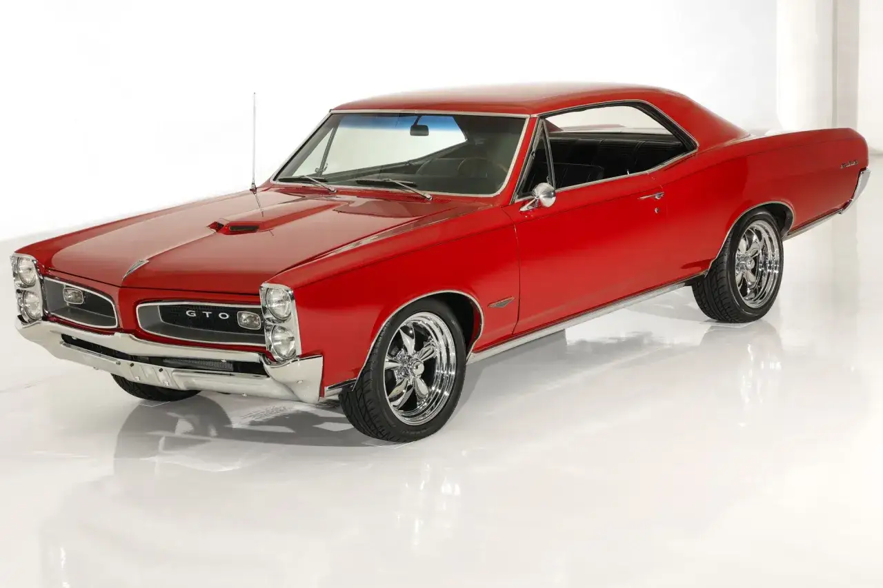 Klasyczny, czerwony Pontiac GTO z lat 60. na błyszczących felgach, gotowy do jazdy.