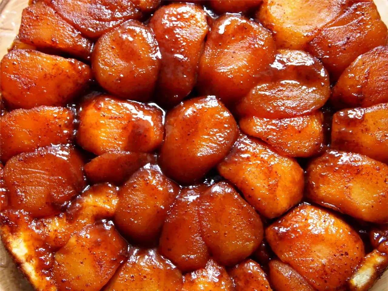 Owoce pod kruszonką, czyli pyszna tarta tatin z karmelizowanymi jabłkami, lśniącymi w syropie.