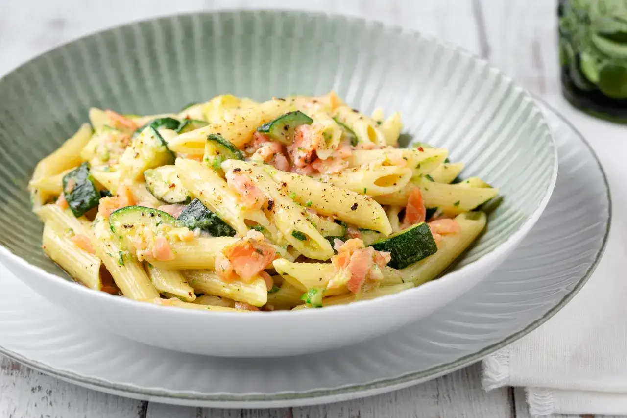 Penne con salmone e zucchine, un piatto cremoso e colorato, pronto per essere gustato.