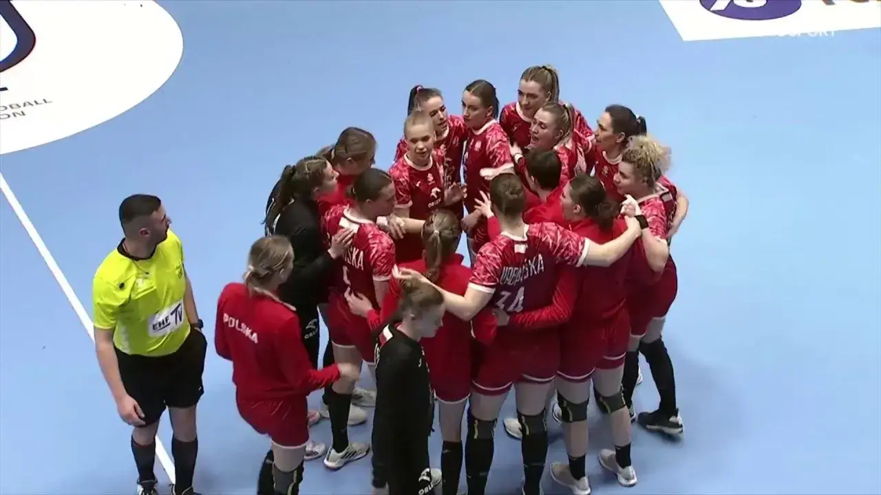Drużyna piłki ręcznej Polska w czerwonych strojach tworzy k&oacute;łko wsparcia.
