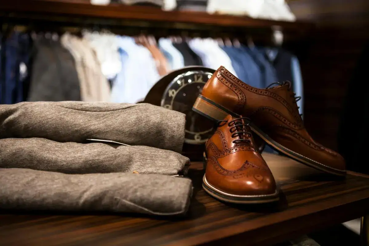 Eleganckie, brązowe **skóra licowa buty** typu oxford, ułożone obok szarych swetrów, gotowe na stylowe wyjście.