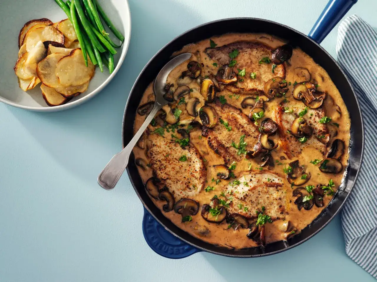 Fl&auml;skkotletter i kr&auml;mig svamps&aring;s, serverade med potatischips och gr&ouml;na b&ouml;nor. Ett perfekt svamps&aring;s recept f&ouml;r middagen.
