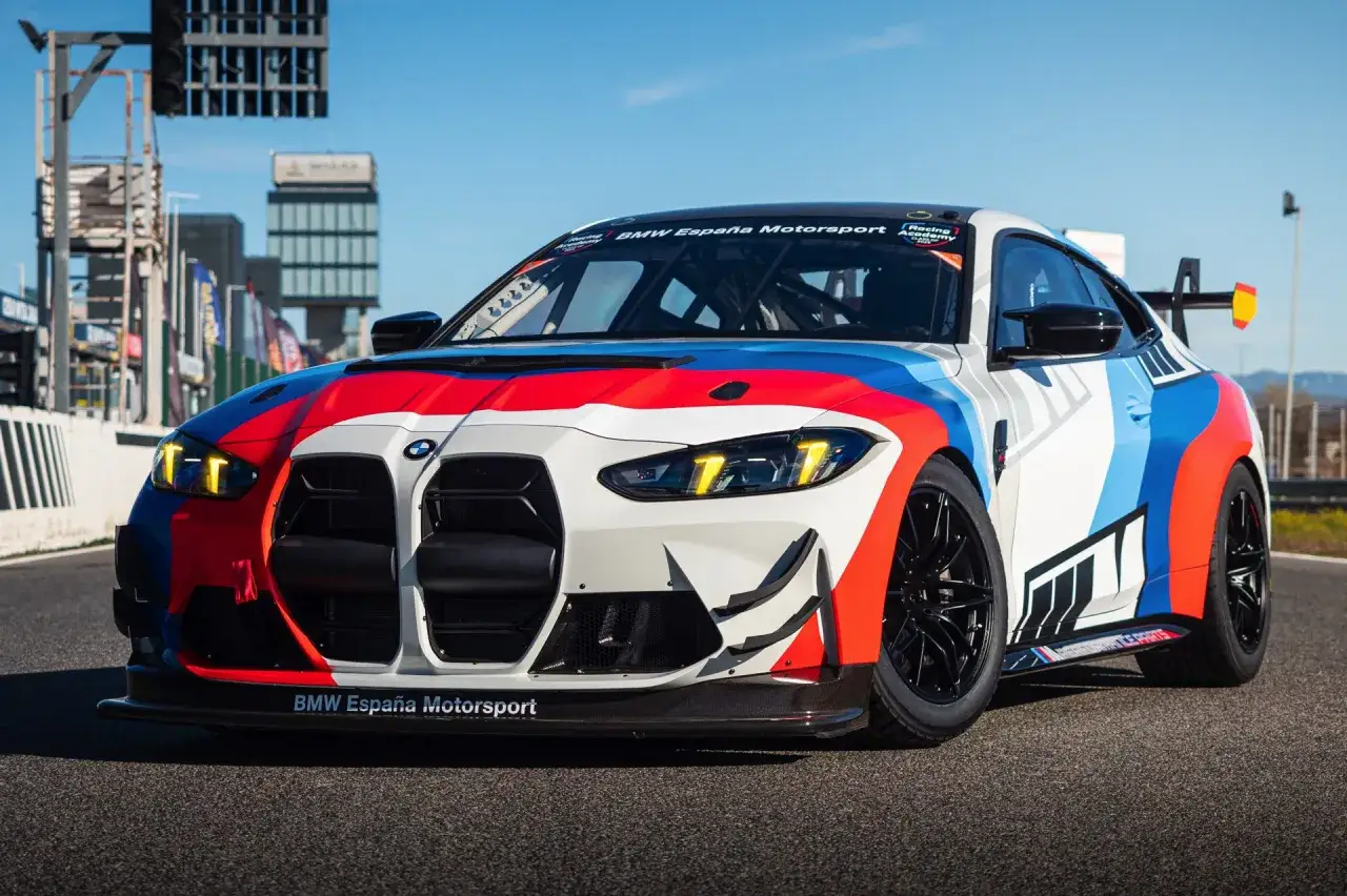 BMW GT4 Rennwagen in auffälliger España Motorsport-Lackierung auf der Rennstrecke, bereit für Höchstgeschwindigkeiten.