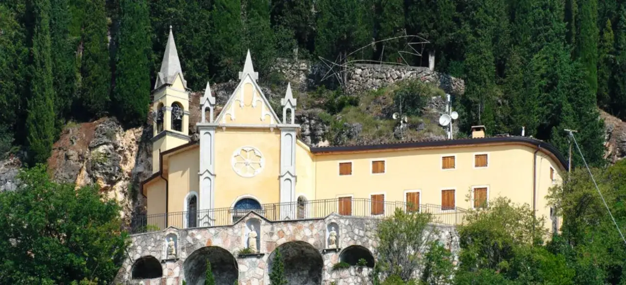 Chiesa gialla con campanile, incastonata tra rocce e cipressi. Un luogo suggestivo da scoprire a Fumane.